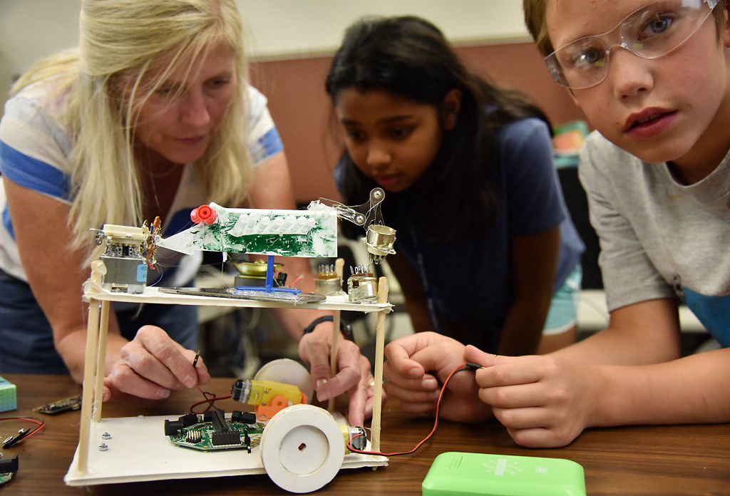 Julie Nichols, Shreeyanka Bardhan, 10, and Dakota Johnson, 9, work on placing wires